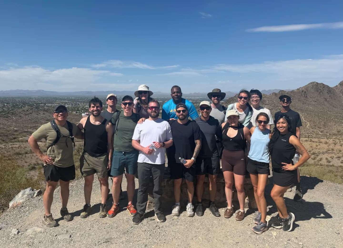A group of Thatch teammates gathered at a desert overlook after a hike